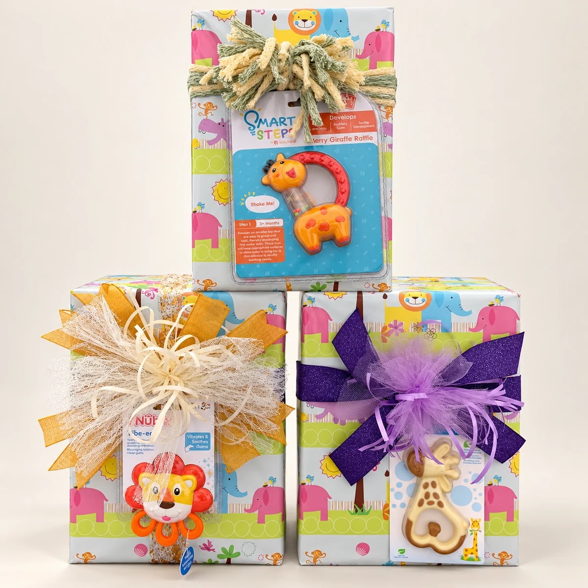 Three baby shower gifts in jungle-animal paper with raffia, gold and purple bows and teething toys tucked in