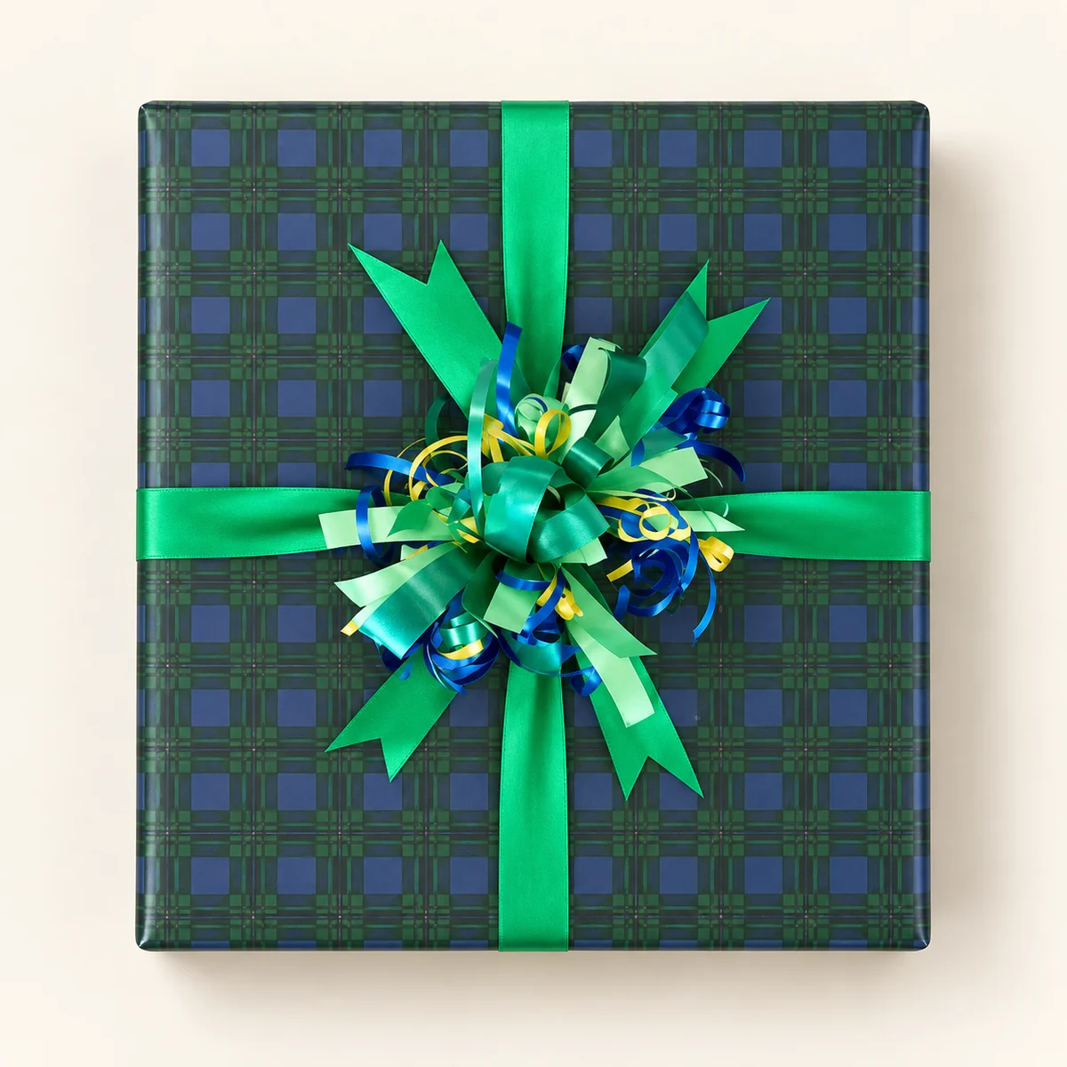 Green and navy plaid paper with emerald ribbon and a curling-ribbon burst